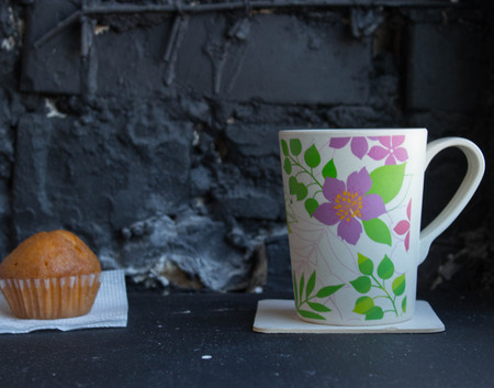 cup with tea and cupcake on black backgroundの写真素材