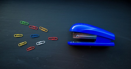 stepler and colored clips on black backgroundの写真素材