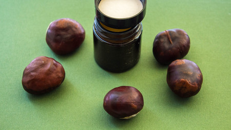 jar of cream and chestnuts on a green backgroundの写真素材