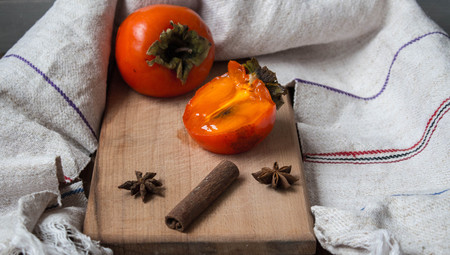 a ripe sliced persimmon and kitchen towlの写真素材