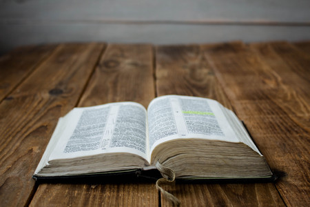a open old bible on wooden backgroundの写真素材