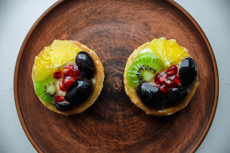 tasty cakes with fresh fruits and berries on a plateの写真素材