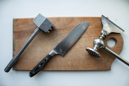 hammer meat and knife and kitchen ax on a wooden deckの写真素材