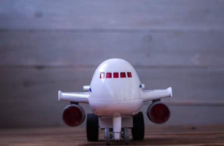 white airplane children's toy on wooden backgroundの写真素材