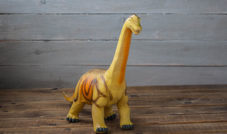 big dinosaur children's toy on a wooden backgroundの写真素材