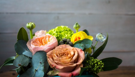 a basket of beautiful flowers on a wooden backgroundの写真素材