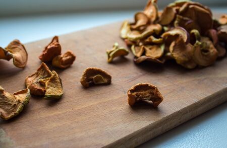 a dried apples on a wooden plate on a white backgroundの写真素材