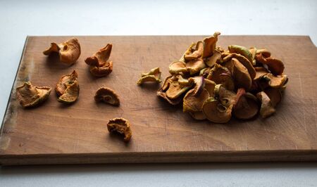 dried apples slices on a wooden plate on a white backgroundの写真素材