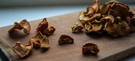 dried apples slices on a wooden plate on a white backgroundの写真素材