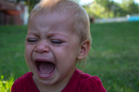 a crying baby in the backyard tearsの写真素材