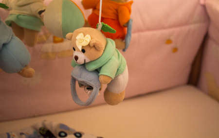 a toy for the newborn in the shape of a bear on a cribの写真素材
