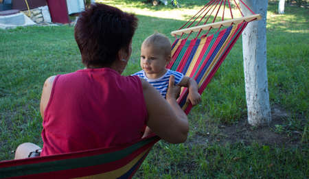a little girl on a hammock with her grandmotherの写真素材