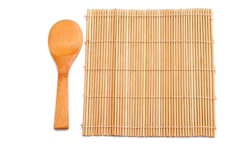 wooden spoon beside bamboo placematの写真素材