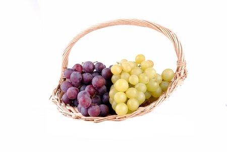 red and green grapes in a straw basket, isolated on whiteの写真素材