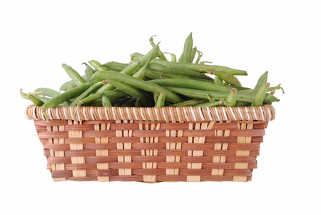green beans in a straw basket, isolated on white