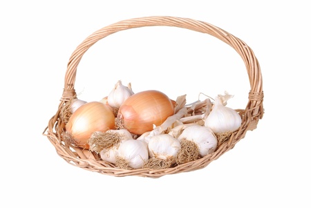 Garlic and onions in a straw basket, isolated on whiteの写真素材