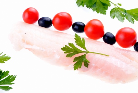 cod steak with tomatoes and parsley isolated on white の写真素材