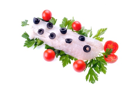 cod steak with tomatoes olives and parsley isolated on white の写真素材