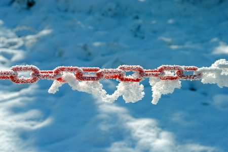 red and white plastic chain covered by snowの写真素材