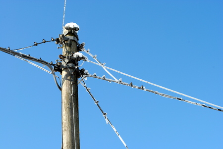 utility pole with electric frozen wires and cablesの写真素材