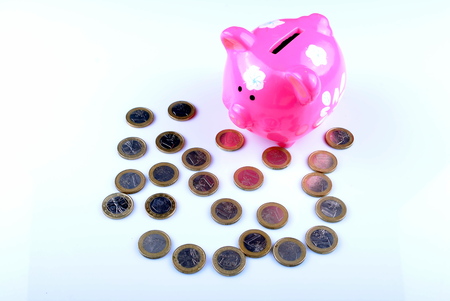 pink piggy bank with euro coinsの写真素材