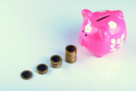 pink piggy bank with euro coinsの写真素材