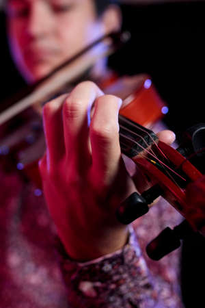 A closed-up detail of violin and musician's hands