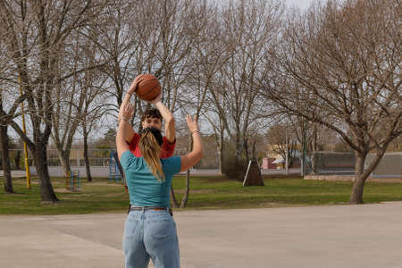 Young woman and man play basketball in the park.の写真素材