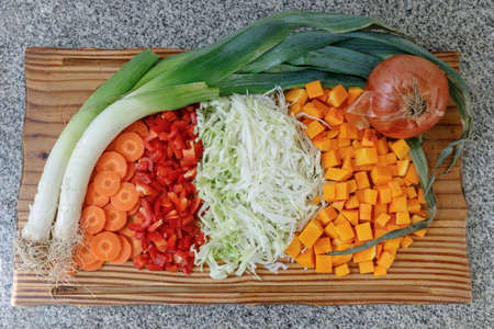 Vegan food. Carrot, red bell peppers, cabbage, pumpkin, onion on a wooden board.の写真素材