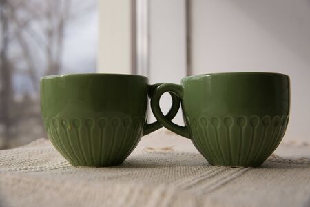 two green mugs photo from the sideの写真素材