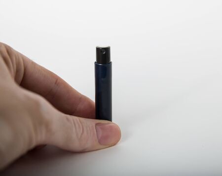 hand holding a black spray bottle for perfumeの写真素材