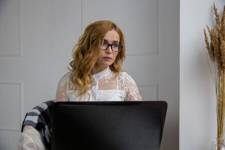the blonde is sitting at her laptop sadの写真素材