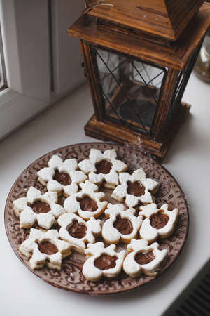 Homemade baked cookies with chocolate on a plate on white windowsill. To cook delicious quarantine at home.の写真素材