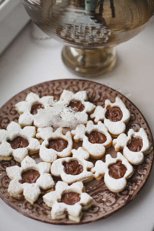 Homemade baked cookies with chocolate on a plate on white windowsill. To cook delicious quarantine at home.の写真素材