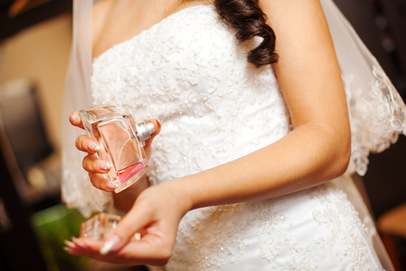 Bride Holds Perfume in Hand and Splashes on Wristの写真素材