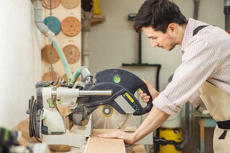 Young turner cuts board with circular saw