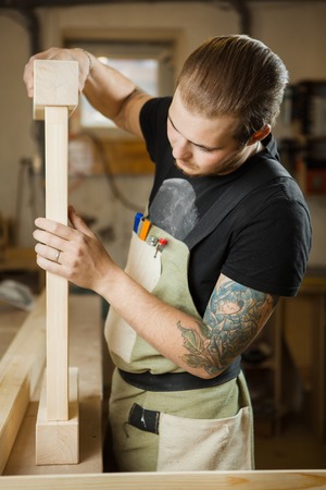 Carpenter does measurements according to project. Woodworker workshopの写真素材