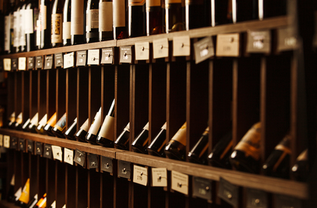 Wine cellar with elite drinks on shelves with written namesの写真素材