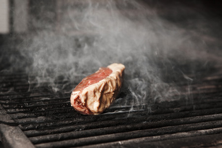 Fresh meat on hot grilled cook with lattice closeup view. Steak preparing on cooker, juicy roasted beef with proteins in cooker stoveの写真素材