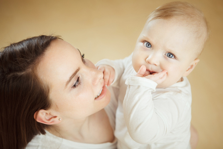 Mother looks at child with care love, baby on armsの写真素材