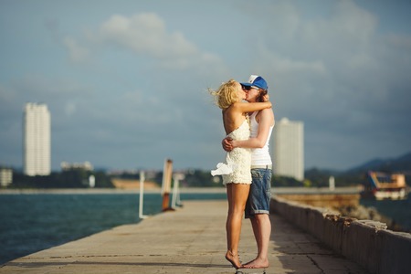 young couple kissing on the pier against the sea. honeymoon lovers.の写真素材