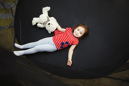 joyful child in the trampoline with soft toy.の写真素材