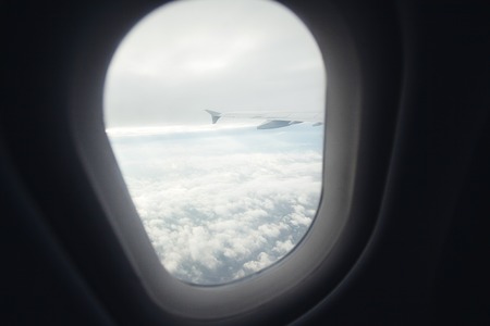 beautiful view from window porthole. the wing of the plane on a background of clouds.