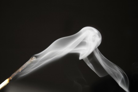 extinguished match with smokeの写真素材
