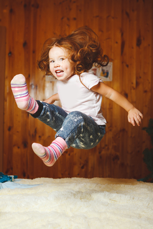 funny baby jumping on the bed.の写真素材