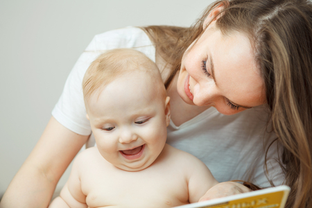 Mother reading to little infant colorful book with fairy tales.の写真素材