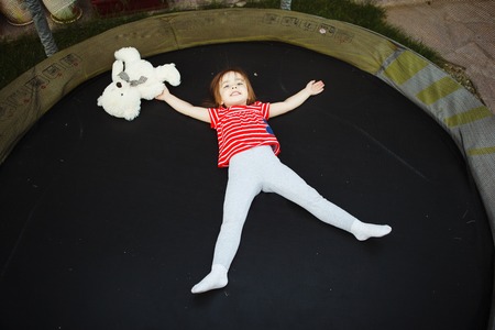 joyful child in the trampoline with soft toy.の写真素材