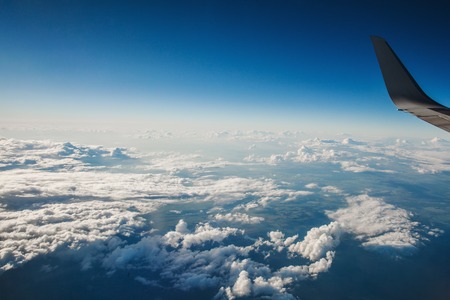 beautiful view from window porthole. wing of the plane on a background of clouds and blue sky....