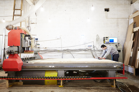 Man sets the program to the CNC machine. Device with numerical control.の写真素材