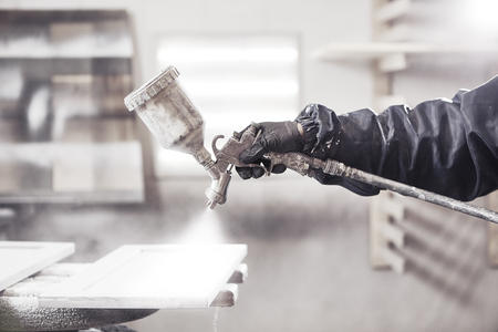 Staining wood with white spray gun. Application of flame retardant ensuring fire protection, airless spraying device.の写真素材